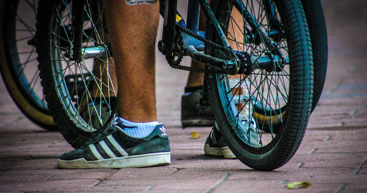 Close-up of a foot next to a bike.
