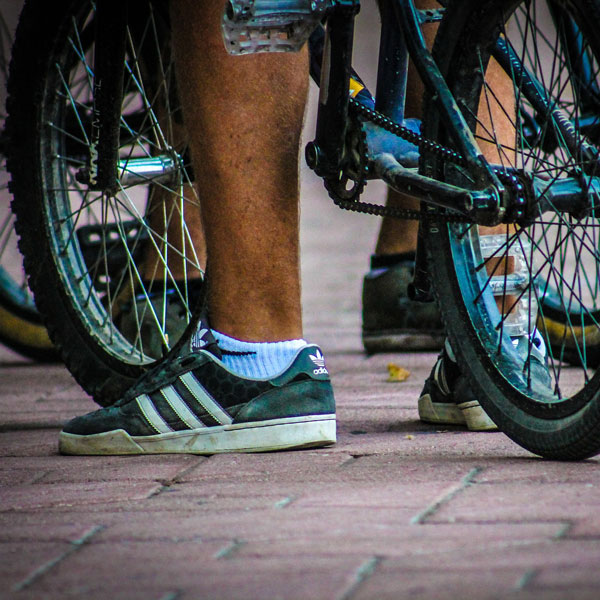 Close-up of a foot next to a bike.